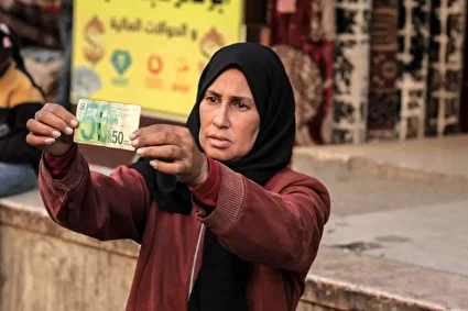 امرار معاش زن فلسطینی با ترمیم اسکناس‌های پاره/تصاویر
